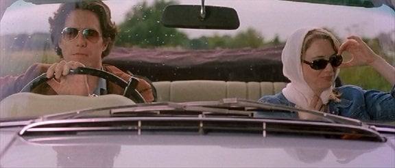 Bridget Jones (Renée Zellweger) looks gleeful in her headscarf on her ride to the country with Daniel Cleaver (Hugh Grant)