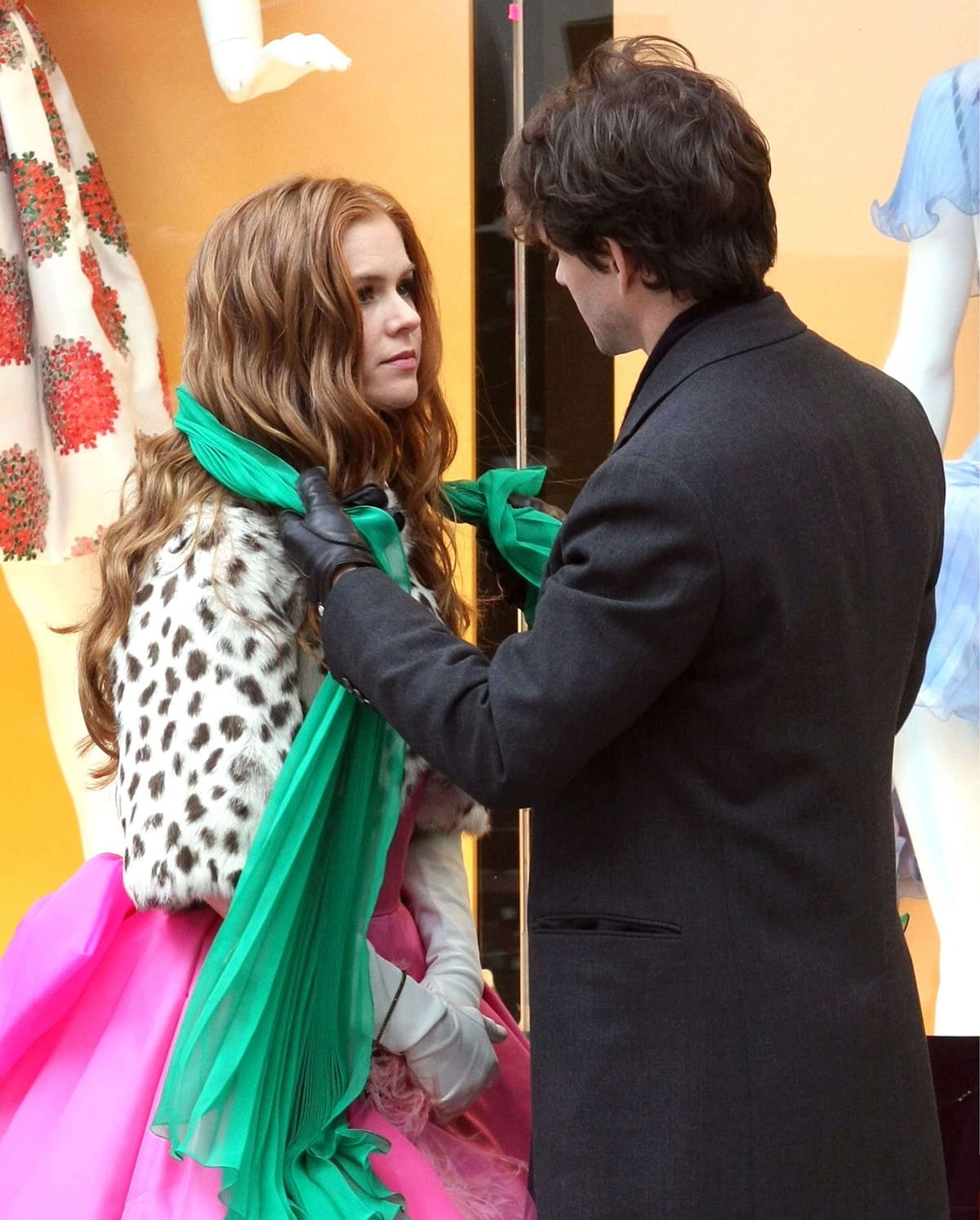 In the 2009 movie "Confessions of a Shopaholic," Isla Fisher's character Rebecca Bloomwood is often seen wearing a green scarf, which is a significant accessory that represents her love for fashion and shopping