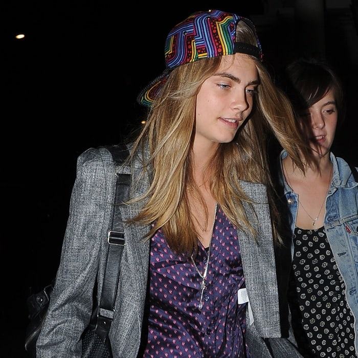 Model Cara Delevingne arriving home in London wearing a colorful cap
