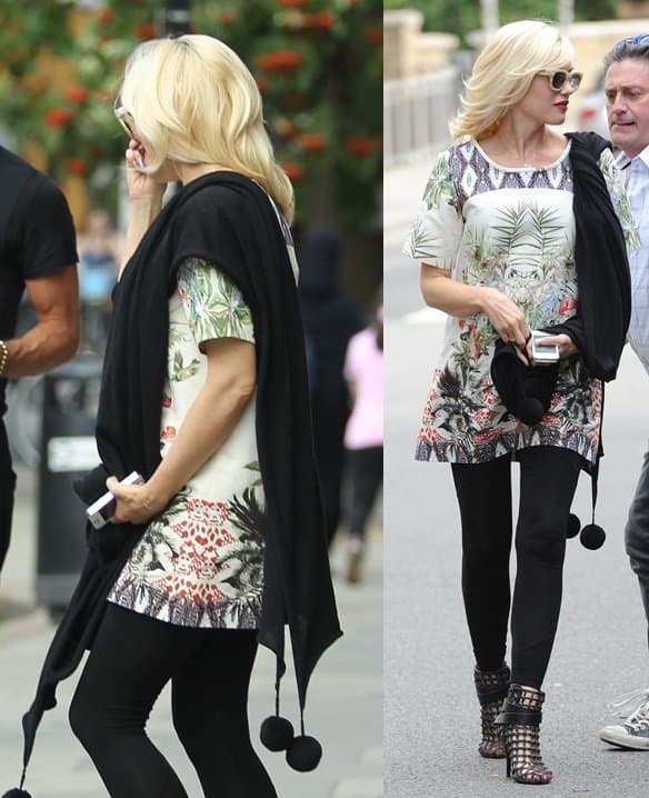 Gwen Stefani in a beautifully printed floral dress with black leggings, cage booties, and a black pom-pom trim stole