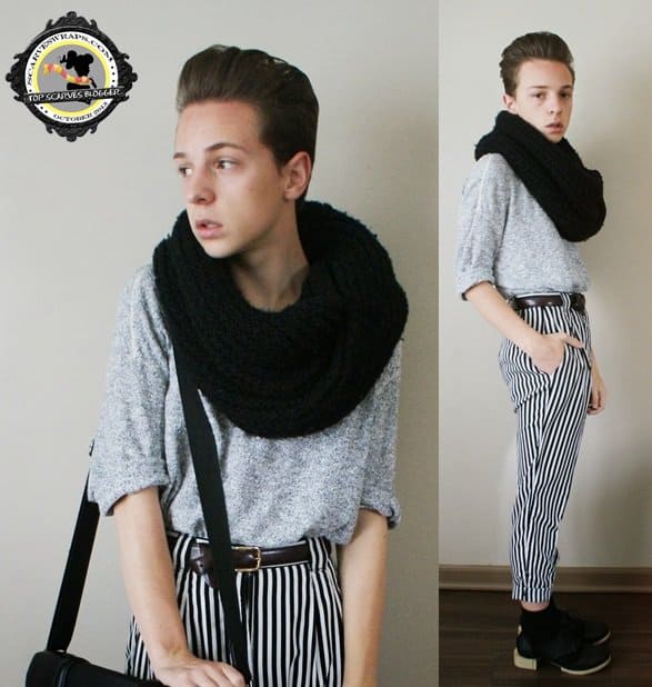 Paul Conrad Schneider highlights his chunky black scarf by pairing it with a light grey sweater and striped trousers