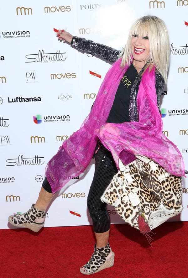 Betsey Johnson wears leopard-print shoes with a matching tote and a hot pink scarf