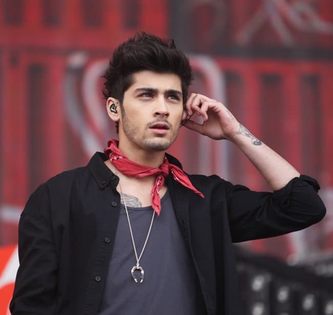 Zayn Malik opted for a sleek and casual 3-piece ensemble in shades of black and gray, and added a bold touch of color with a red neckerchief to complete his look
