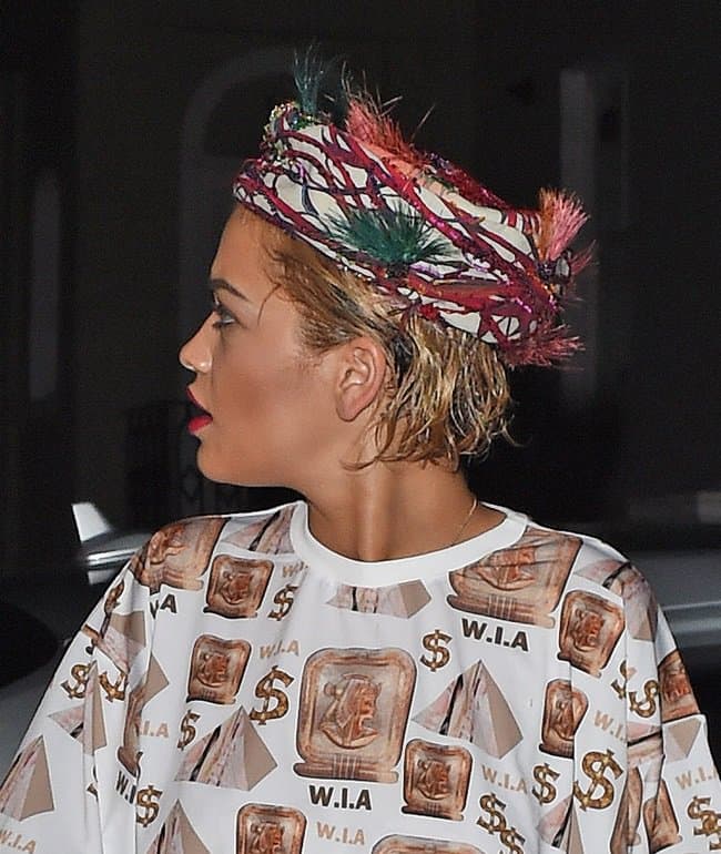 Rita Ora wears a dollar-print outfit with a printed head wrap