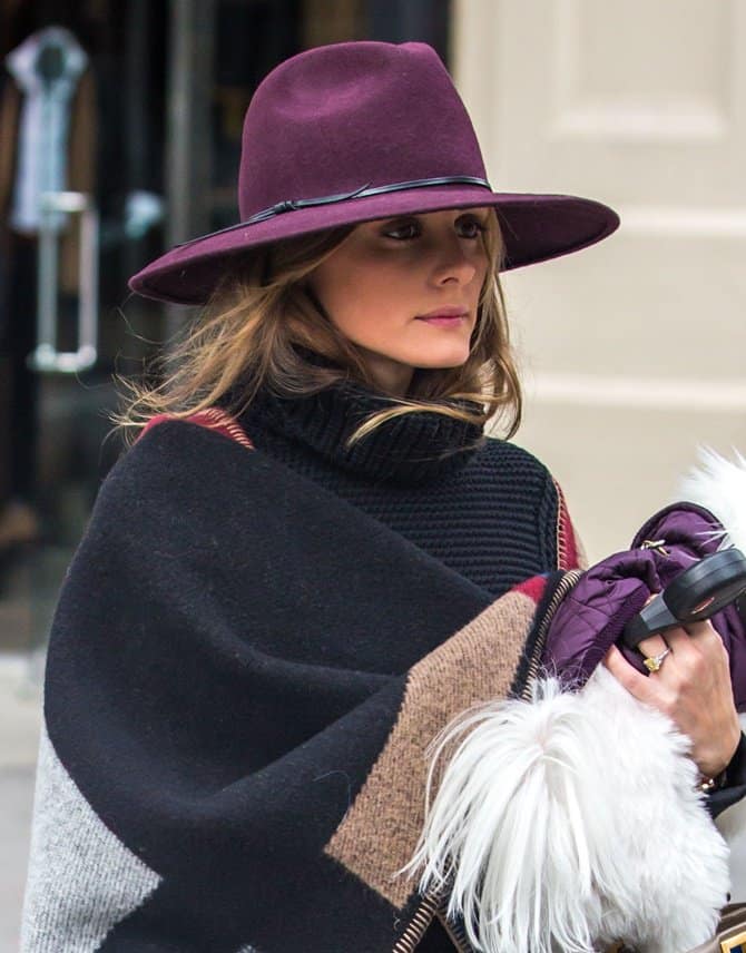 Olivia Palermo turns an all-black attire into something more elaborate with the use of a patterned blanket wrap, a purple hat, and a pair of floral flats while running errands in Brooklyn, New York City, on October 21, 2014