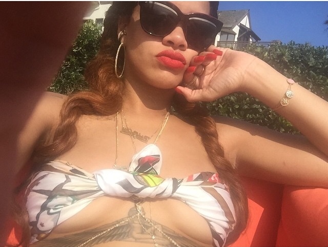 Rihanna effortlessly showcases her unique fashion sense as she lounges poolside, casually pairing a luxurious Hermes silk scarf with her bikini